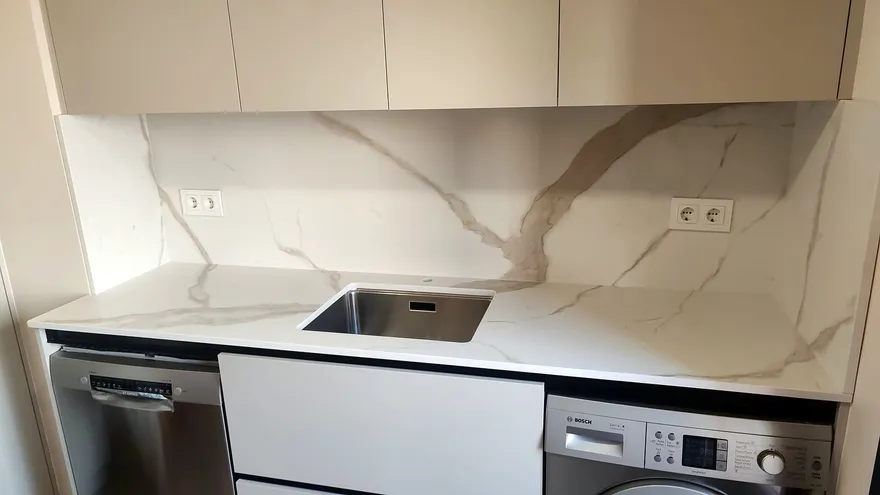 Encimera y frente de porcelánico Laminam Calacatta Michelangelo mate con veta gris y dorada y fregadero bajo encimera: encimera montada por Kitchenmania